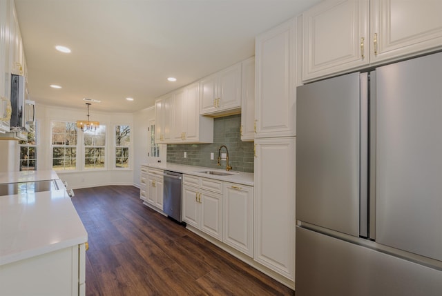 kitchen featuring dark wood-type flooring, stainless steel appliances, light countertops, white cabinetry, and a sink