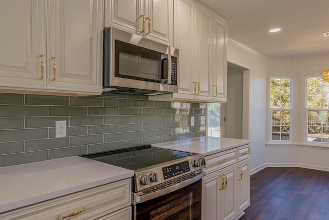 kitchen featuring stainless steel appliances, white cabinets, crown molding, and tasteful backsplash