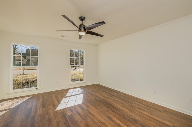 spare room with baseboards, crown molding, visible vents, and wood finished floors