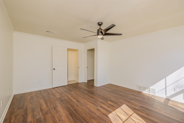 unfurnished room featuring baseboards, wood finished floors, visible vents, and crown molding