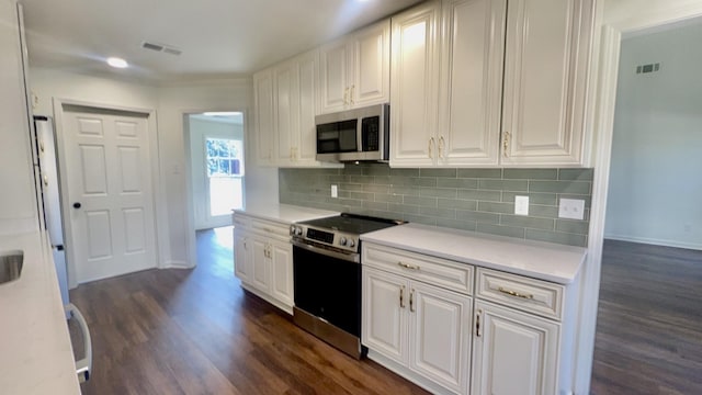 kitchen with stainless steel appliances, dark wood-type flooring, visible vents, and white cabinetry