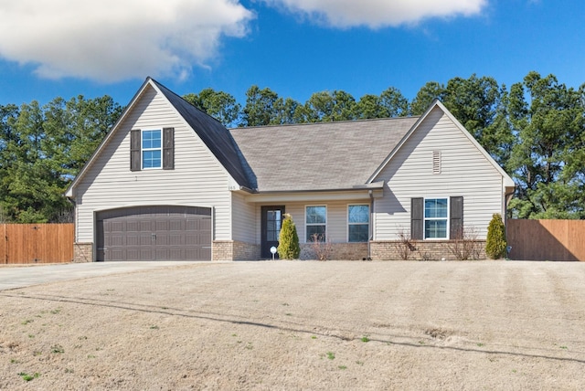 view of front of home featuring a garage, driveway, brick siding, and fence