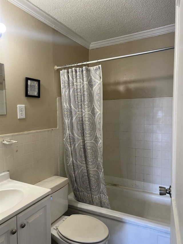 bathroom featuring tile walls, ornamental molding, shower / bath combo, a textured ceiling, and vanity