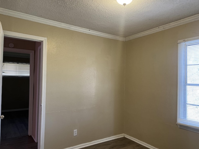 empty room with dark wood-style floors, a textured ceiling, plenty of natural light, and crown molding