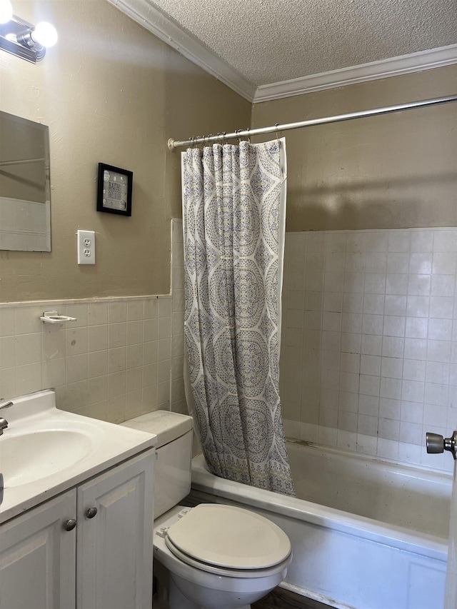 full bathroom featuring toilet, vanity, crown molding, a textured ceiling, and tile walls