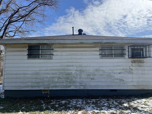 snow covered property with crawl space and roof with shingles