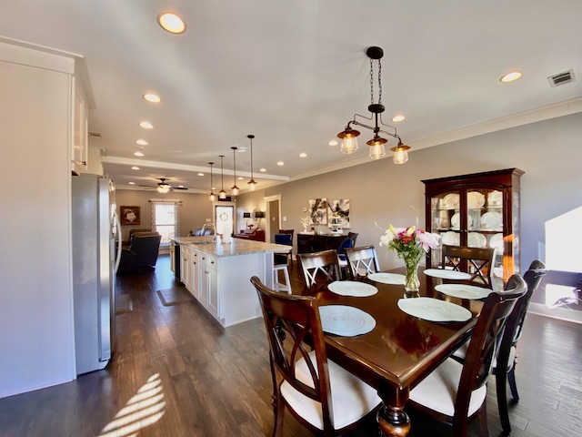 dining room with crown molding, dark wood finished floors, visible vents, and recessed lighting