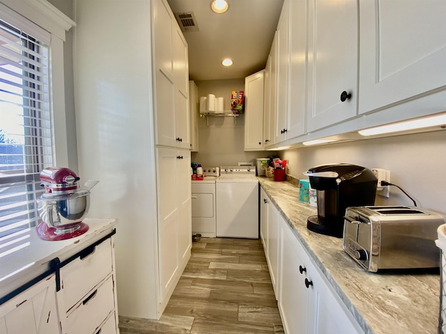 clothes washing area featuring a toaster, recessed lighting, cabinet space, light wood-type flooring, and independent washer and dryer