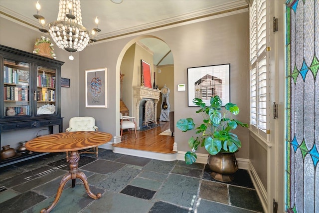 office space with arched walkways, a fireplace, stone tile flooring, and crown molding