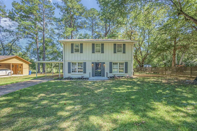 colonial house with brick siding, board and batten siding, fence, a carport, and a front lawn