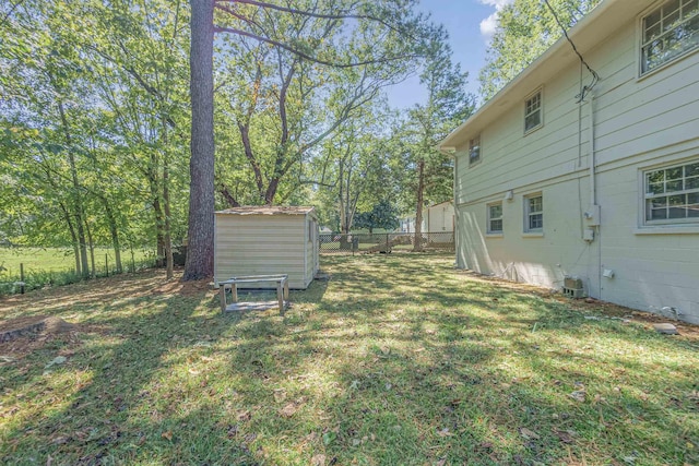 view of yard with an outbuilding, a shed, and fence