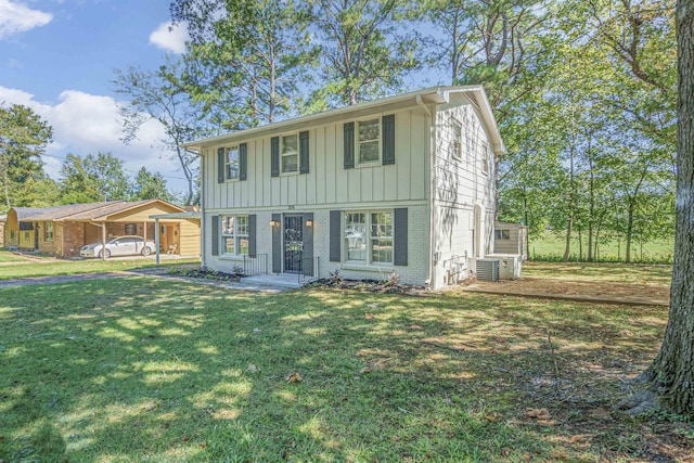 colonial house with brick siding, board and batten siding, a front lawn, and central air condition unit