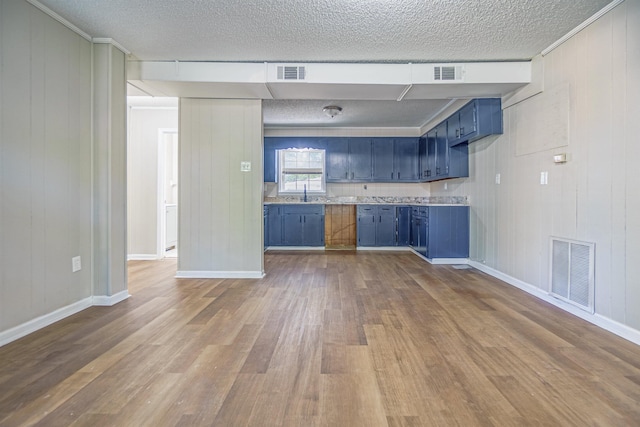 kitchen with blue cabinets, light countertops, and visible vents