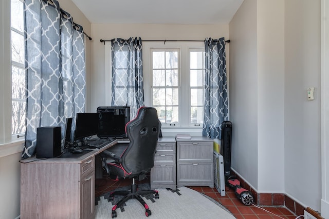 office area with dark tile patterned floors and baseboards