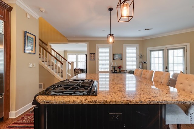 kitchen featuring crown molding, light stone counters, and pendant lighting