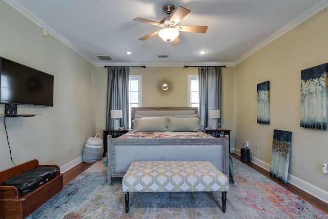 bedroom featuring ornamental molding, visible vents, baseboards, and wood finished floors