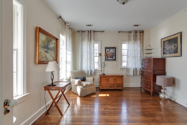 living area with dark wood-style floors, visible vents, and baseboards