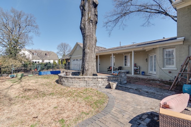 rear view of house featuring an attached garage, fence, and brick siding