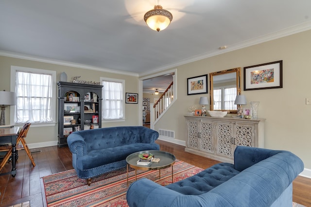 living area with crown molding, visible vents, and wood finished floors