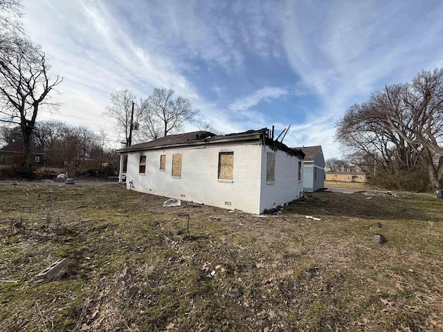 view of side of property with brick siding and crawl space