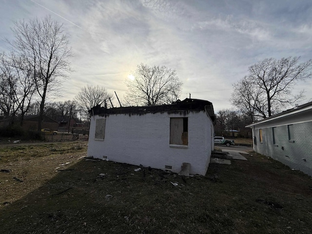 view of side of home with crawl space and brick siding