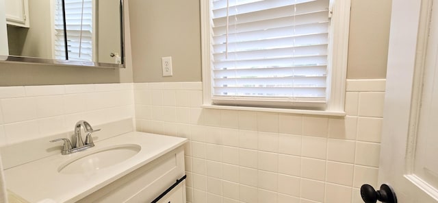 bathroom with wainscoting, tile walls, and vanity