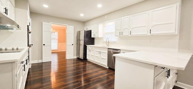 kitchen featuring light stone counters, dark wood-style flooring, stainless steel appliances, white cabinetry, and recessed lighting