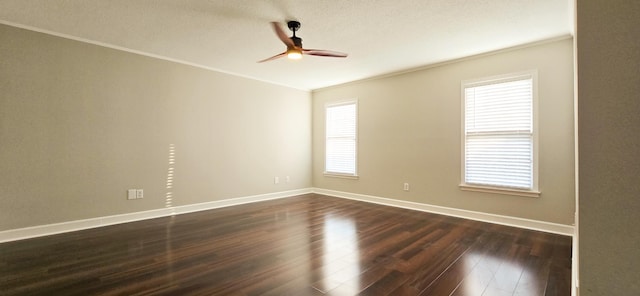 spare room featuring baseboards, ceiling fan, ornamental molding, and dark wood-type flooring