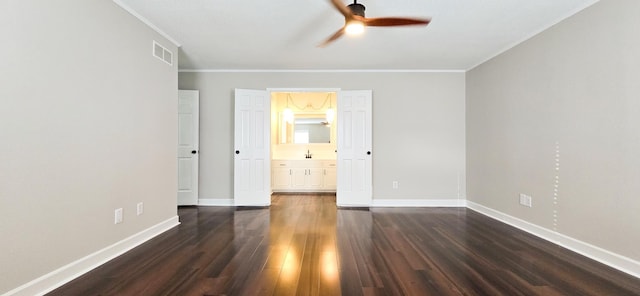 unfurnished bedroom featuring connected bathroom, visible vents, baseboards, dark wood-style floors, and crown molding