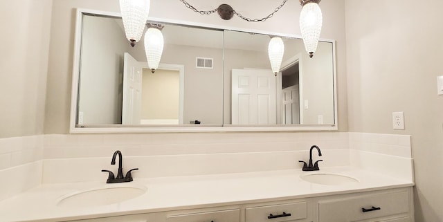 full bath with double vanity, visible vents, and a sink