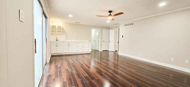 interior space with baseboards, visible vents, ceiling fan, dark wood-style flooring, and crown molding