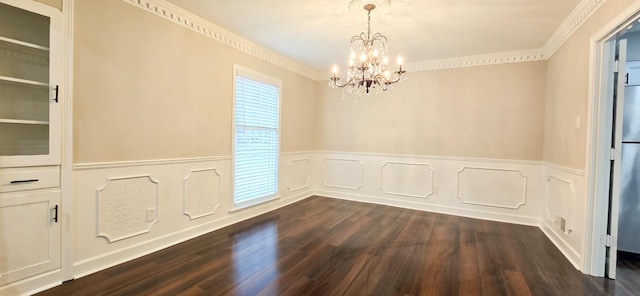 empty room with ornamental molding, dark wood-type flooring, a wainscoted wall, and a chandelier