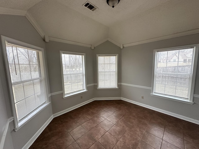 unfurnished room featuring baseboards, visible vents, lofted ceiling, a textured ceiling, and crown molding