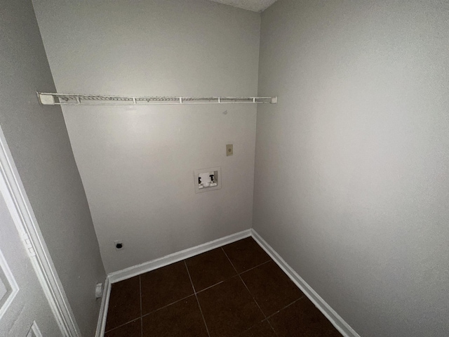 laundry area with hookup for a washing machine, hookup for an electric dryer, laundry area, dark tile patterned floors, and baseboards