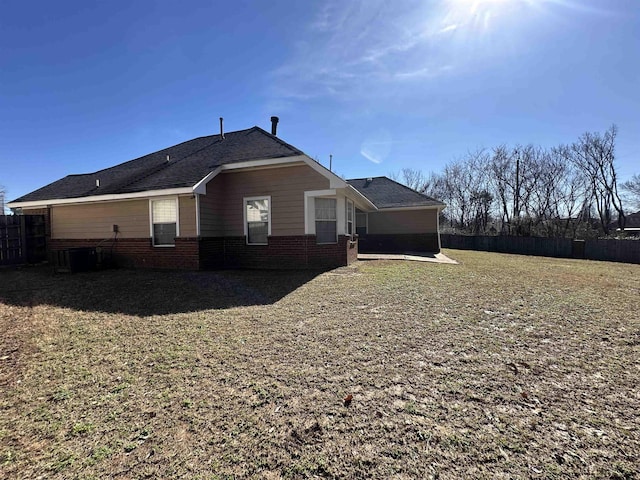 view of property exterior with a patio area, fence, and brick siding