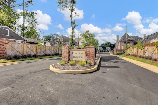 community / neighborhood sign featuring a residential view and fence