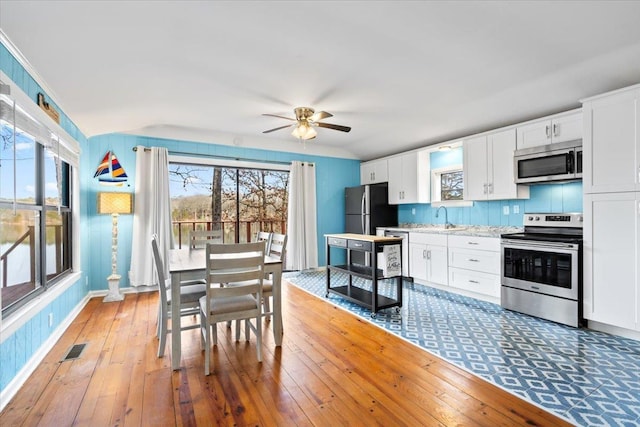 kitchen with visible vents, white cabinetry, stainless steel appliances, and a wealth of natural light