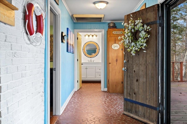 corridor with brick wall, visible vents, and crown molding