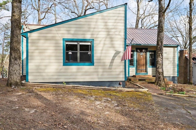 view of front facade with entry steps and metal roof