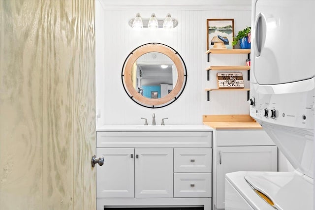 bathroom with stacked washer / drying machine and vanity