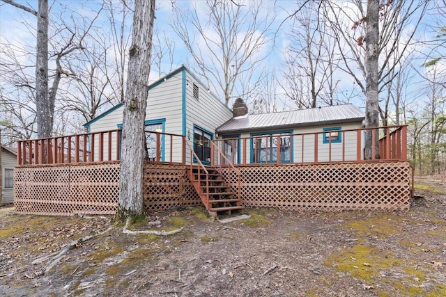 back of property featuring a deck, metal roof, and a chimney