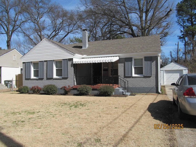 bungalow featuring a garage, an outbuilding, brick siding, and a chimney