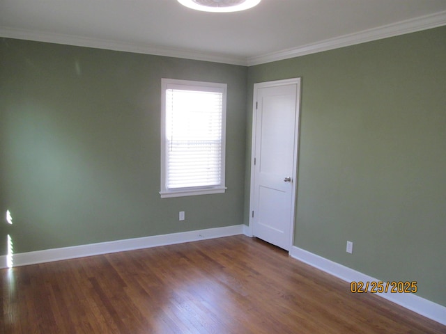 spare room featuring baseboards, dark wood-type flooring, and ornamental molding