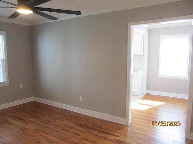 empty room featuring ornamental molding, ceiling fan, baseboards, and wood finished floors