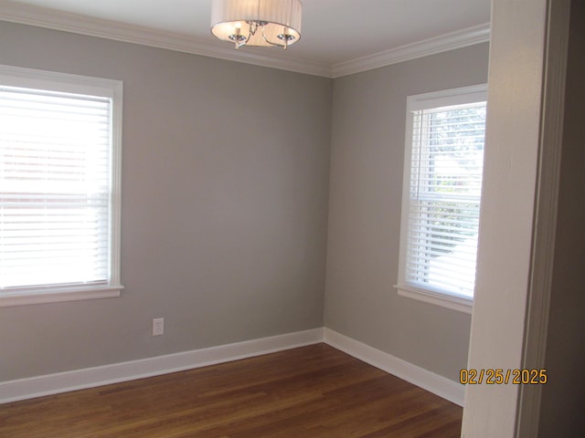 empty room featuring dark wood-type flooring, ornamental molding, and baseboards