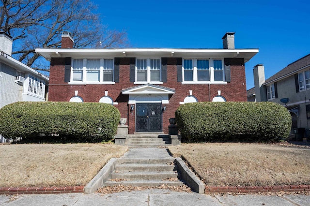 view of front of property with brick siding and a chimney