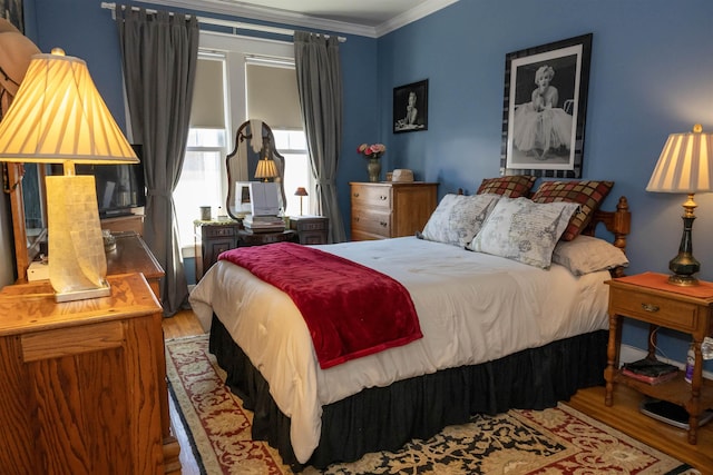 bedroom with crown molding and wood finished floors