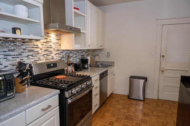 kitchen featuring open shelves, wall chimney range hood, white cabinetry, and stainless steel appliances