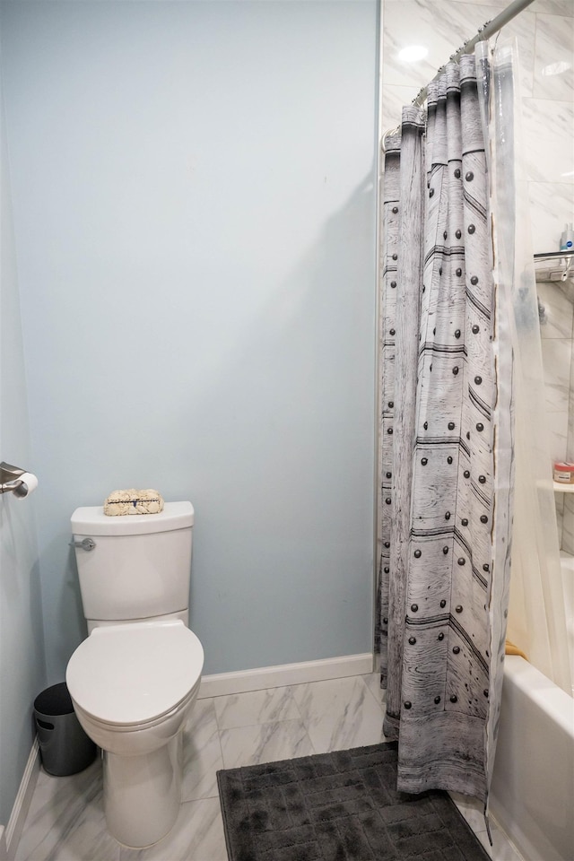 bathroom featuring marble finish floor, toilet, baseboards, and shower / bath combo with shower curtain