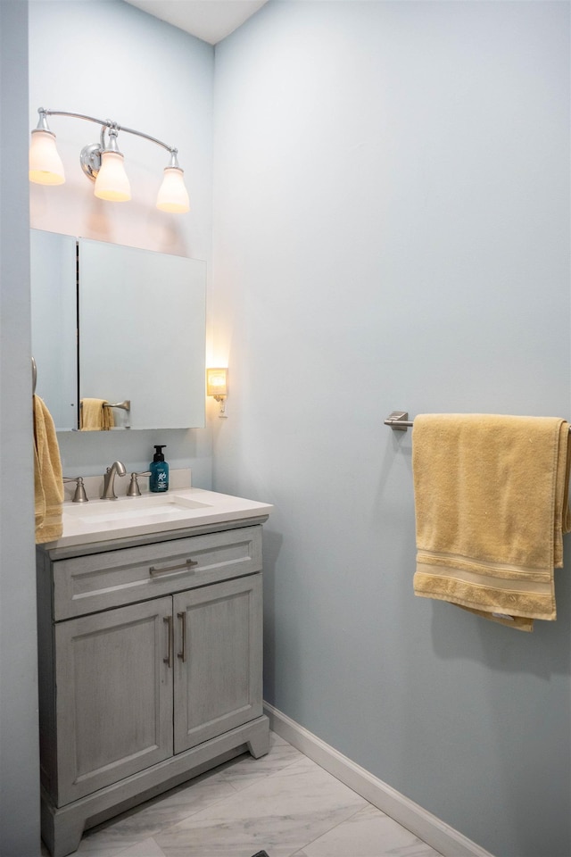 bathroom with marble finish floor, baseboards, and vanity